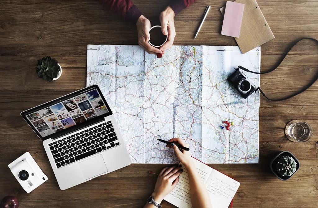 Mensen onderzoeken locaties met een kaart en laptop